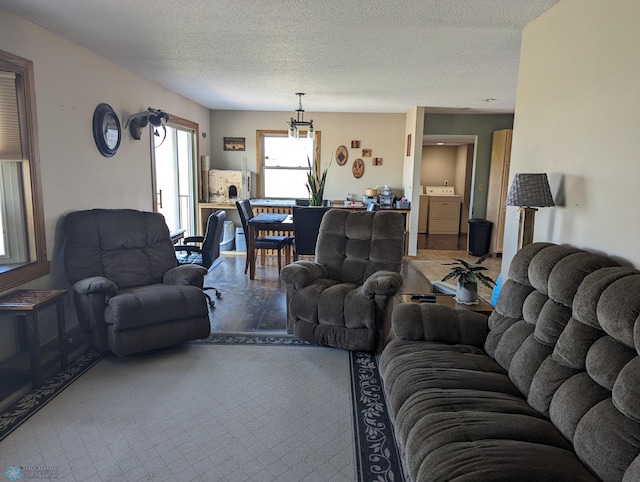 living room featuring washing machine and clothes dryer and a textured ceiling