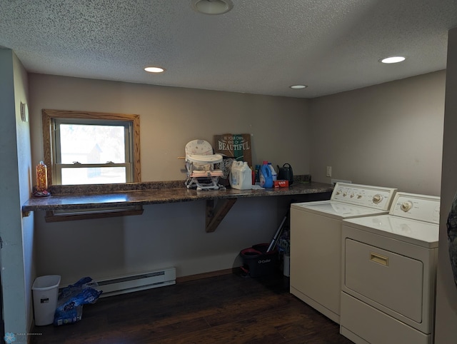 laundry room featuring washing machine and clothes dryer, dark wood-type flooring, a baseboard radiator, and a textured ceiling