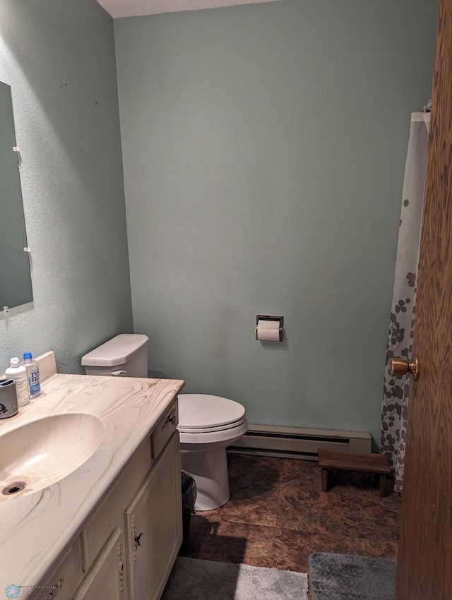 bathroom featuring a baseboard heating unit, toilet, and vanity