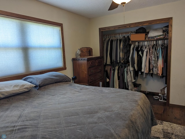 bedroom featuring hardwood / wood-style floors, a textured ceiling, multiple windows, ceiling fan, and a closet