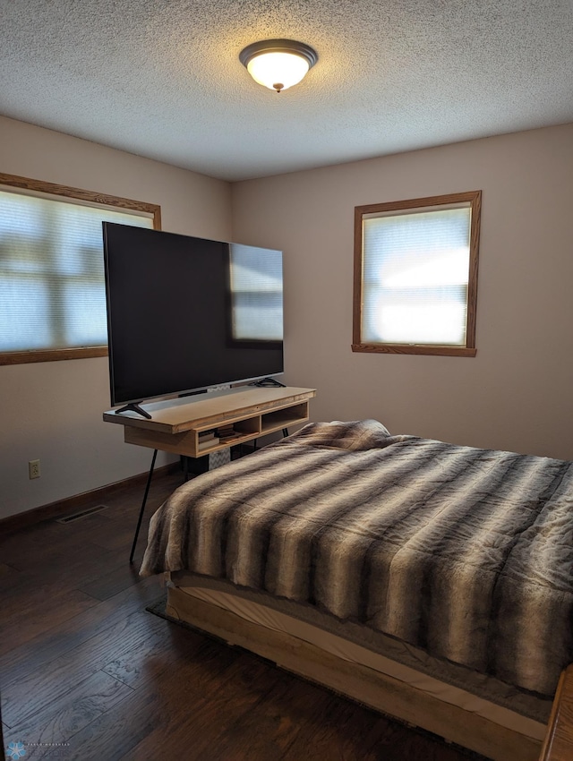 bedroom featuring dark wood-type flooring and a textured ceiling