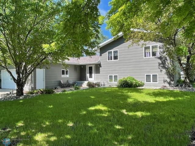 rear view of property featuring a lawn