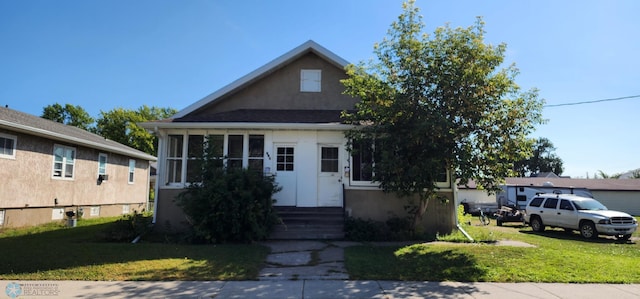 bungalow-style house with a front lawn