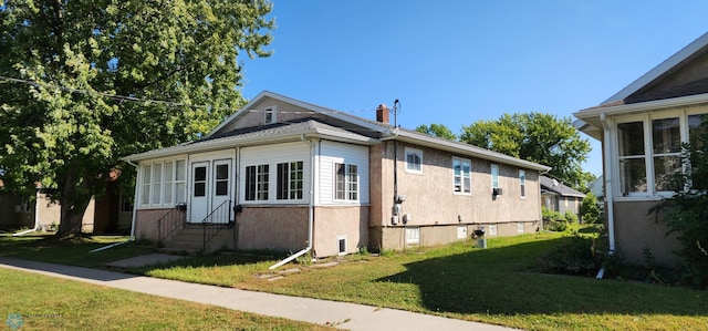 view of side of home with a lawn