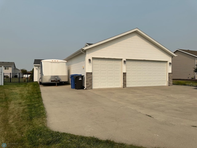 view of side of property featuring a yard, an outdoor structure, and a garage