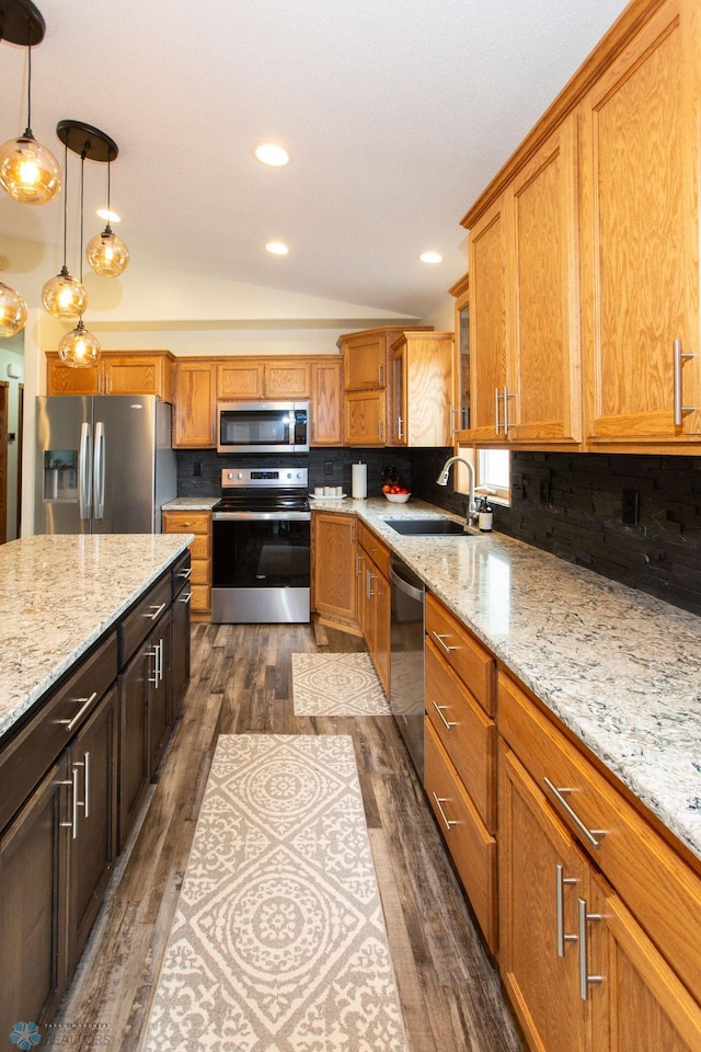 kitchen featuring appliances with stainless steel finishes, hanging light fixtures, dark wood-type flooring, and lofted ceiling