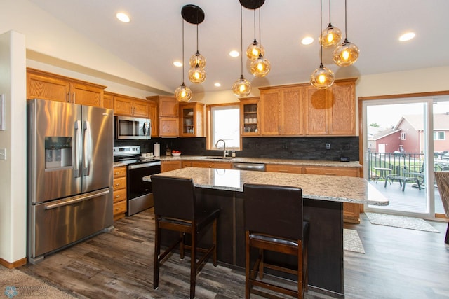 kitchen with a kitchen island, stainless steel appliances, lofted ceiling, and a wealth of natural light