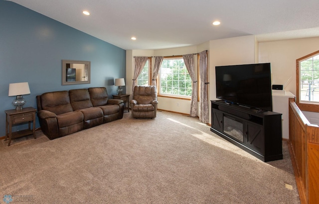 carpeted living room with a wealth of natural light and lofted ceiling