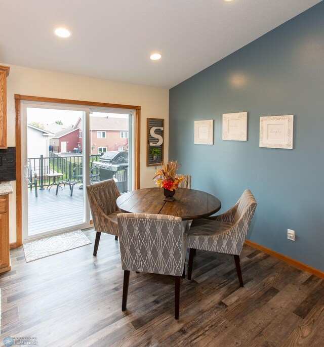 dining space with vaulted ceiling and dark hardwood / wood-style flooring