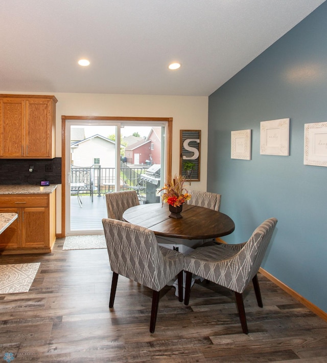 dining area featuring lofted ceiling and dark wood-type flooring