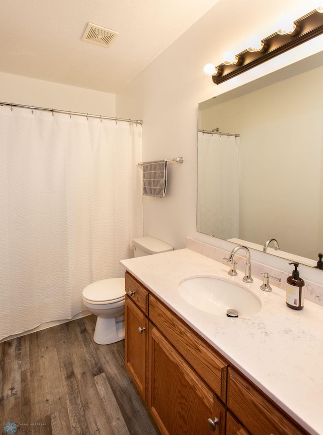 bathroom featuring vanity, toilet, and hardwood / wood-style flooring