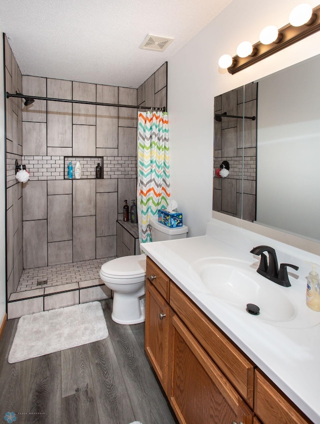 bathroom with wood-type flooring, vanity, toilet, and a shower with shower curtain