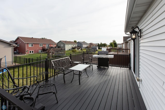 wooden terrace featuring grilling area and a yard