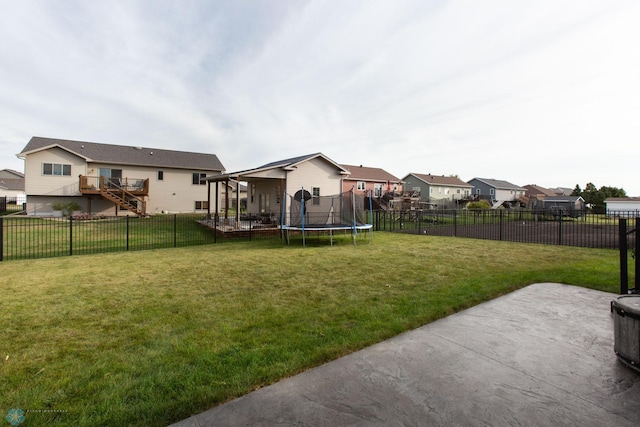 view of yard with a trampoline and a patio