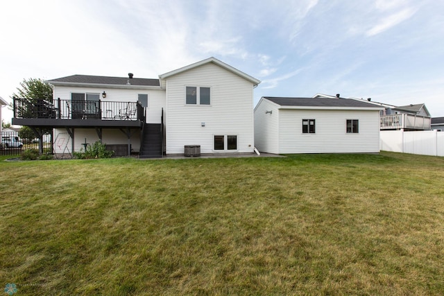 rear view of house featuring cooling unit, a wooden deck, a yard, and a patio area