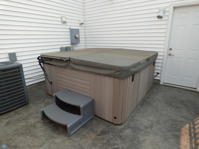 view of patio with cooling unit and a hot tub