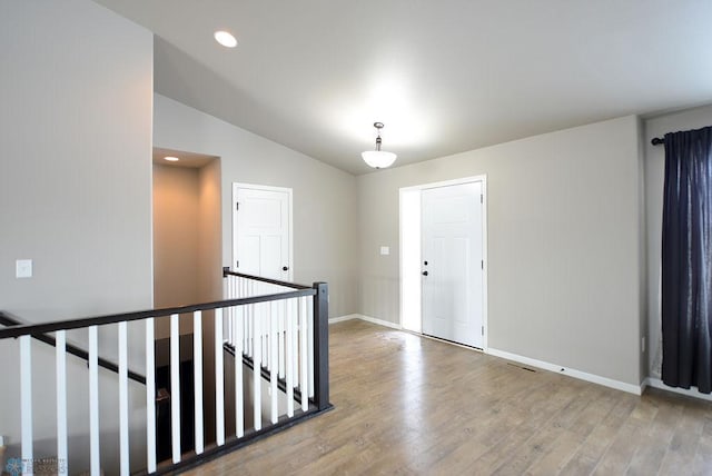 unfurnished room with lofted ceiling and hardwood / wood-style floors