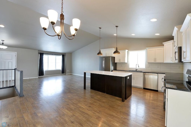 kitchen featuring plenty of natural light, stainless steel appliances, a chandelier, and a kitchen island