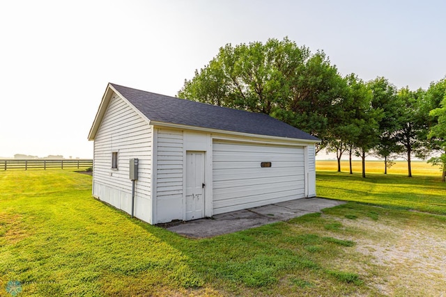 garage with a yard and a rural view