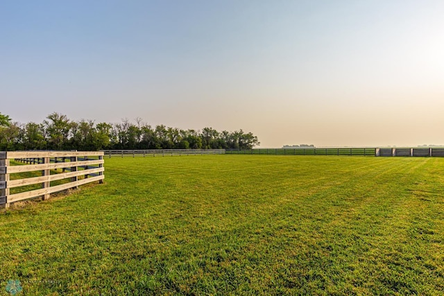 yard at dusk featuring a rural view