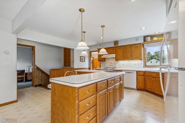 kitchen with sink, decorative light fixtures, white appliances, and a kitchen island with sink