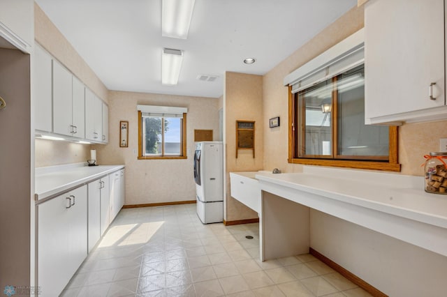 kitchen with white cabinetry and washing machine and dryer