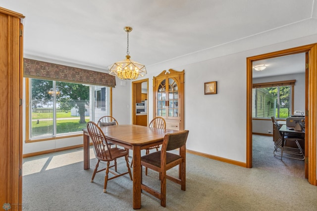 carpeted dining space featuring a chandelier