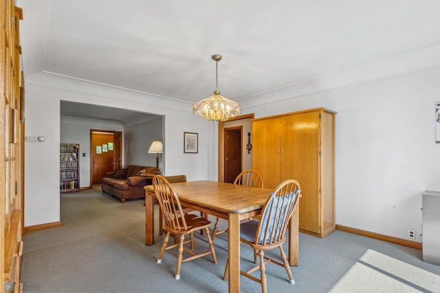 carpeted dining area featuring a chandelier