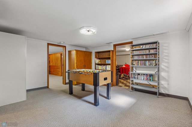 rec room with ornamental molding and light colored carpet