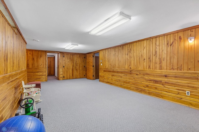 basement featuring wood walls and light carpet