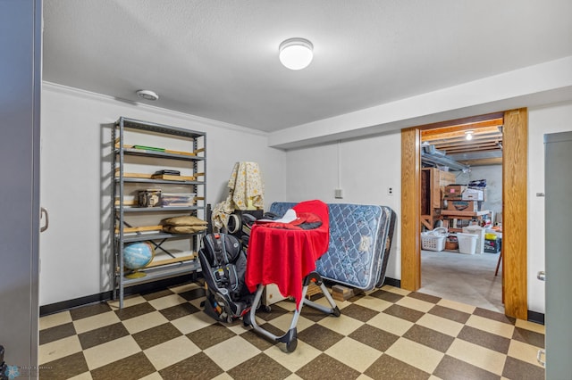 basement featuring a textured ceiling and ornamental molding