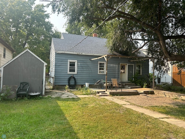 back of property featuring a lawn, a storage unit, and a patio area