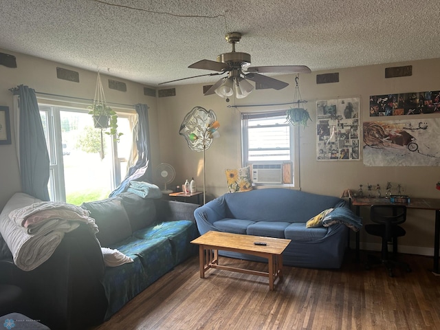 living room with dark wood-type flooring, ceiling fan, cooling unit, and a textured ceiling