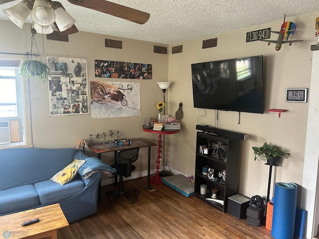 living room featuring dark wood-type flooring, a textured ceiling, and ceiling fan