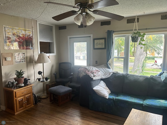 living room with ceiling fan, dark hardwood / wood-style floors, and a textured ceiling