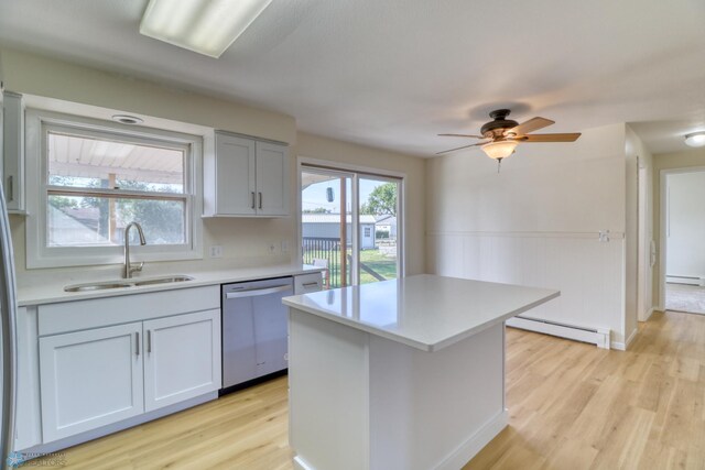 kitchen with light hardwood / wood-style floors, stainless steel dishwasher, sink, and a baseboard heating unit