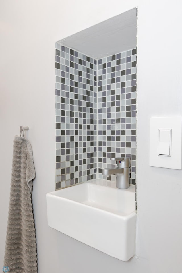 bathroom featuring backsplash and sink