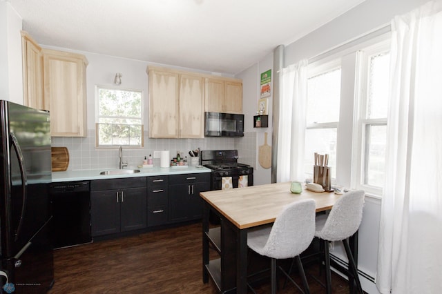 kitchen featuring backsplash, sink, black appliances, dark wood-type flooring, and a breakfast bar