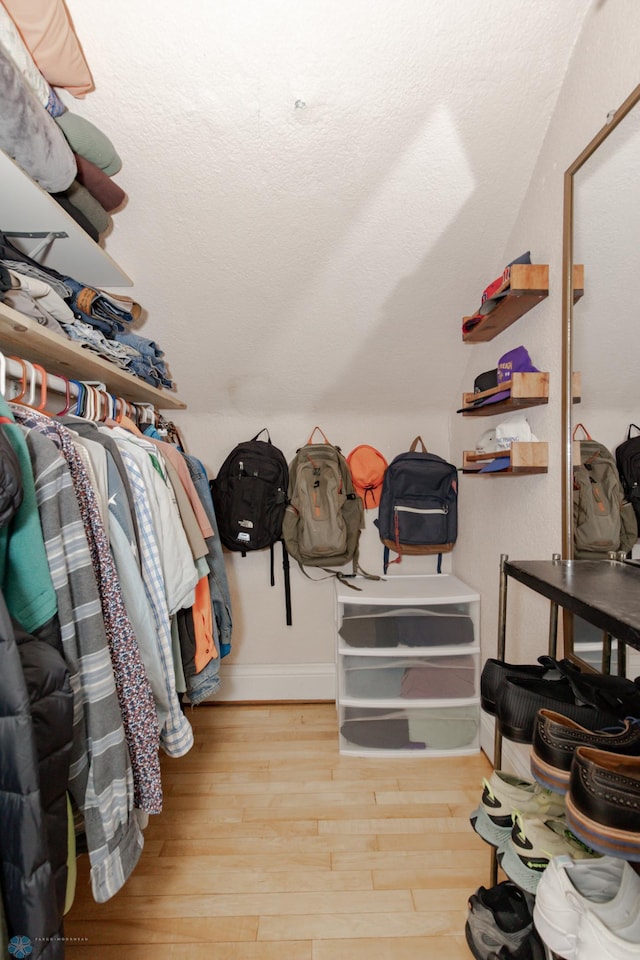 walk in closet with light hardwood / wood-style floors