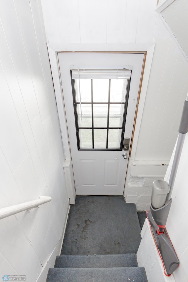 doorway to outside featuring dark colored carpet