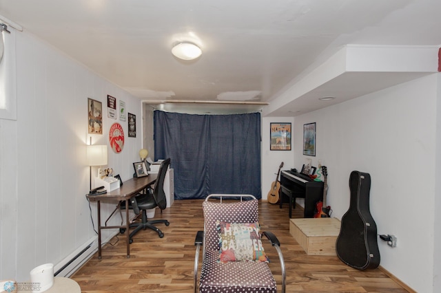 home office featuring a baseboard heating unit and hardwood / wood-style flooring