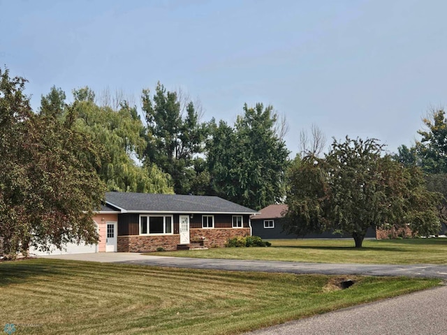 single story home featuring a garage and a front lawn