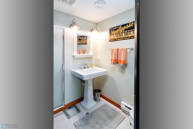 bathroom featuring a baseboard radiator, sink, and tile patterned flooring