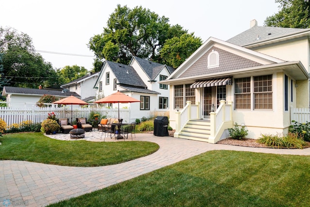 back of house featuring a fire pit, a yard, and a patio area