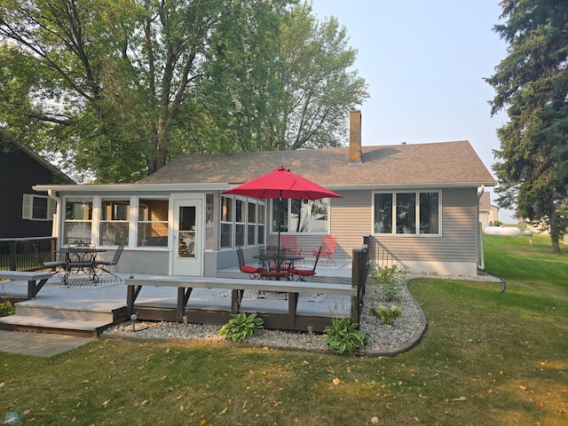 back of property with a deck and a lawn