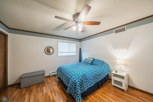 bedroom featuring dark wood-type flooring, ceiling fan, a textured ceiling, and a baseboard heating unit