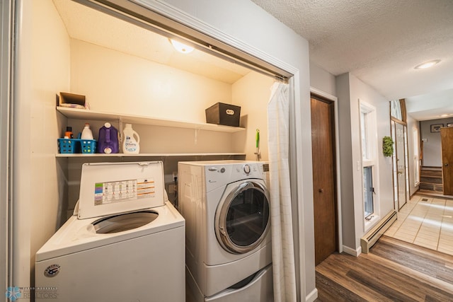 clothes washing area featuring independent washer and dryer, a textured ceiling, a baseboard radiator, and dark hardwood / wood-style floors