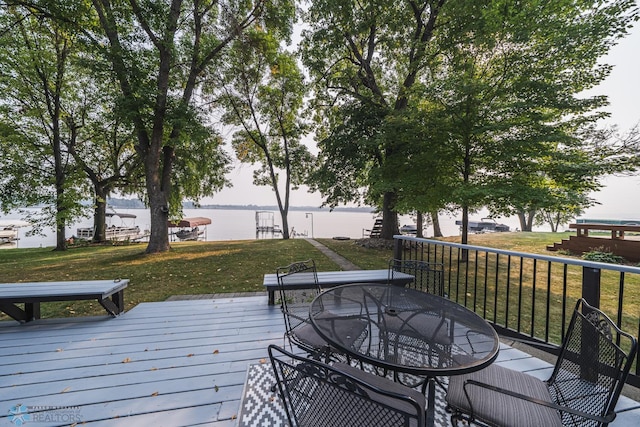 wooden terrace featuring a lawn and a water view