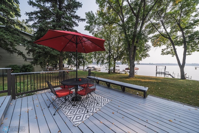 deck featuring a water view and a lawn