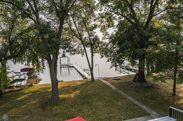 view of yard with a water view and a dock